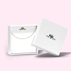 An open white jewellery box with the lid leaning against it, containing a necklace inside.