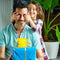 A little girl playfully covering her father's eyes while presenting him with a gift.
