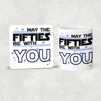 Coaster and White ceramic mug with "MAY THE FIFTIES BE WITH YOU" in black and blue typography, decorated with stars - perfect 50th birthday gift