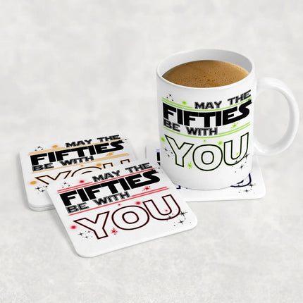 White ceramic mug and coasters with "MAY THE FIFTIES BE WITH YOU" in black, green, yellow and stars - perfect 50th birthday gift