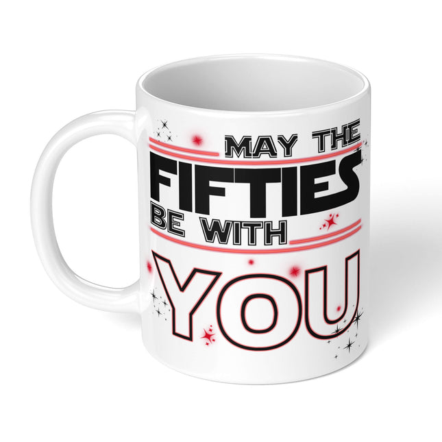 White ceramic mug with "MAY THE FIFTIES BE WITH YOU" in black and red typography, decorated with stars - perfect 50th birthday gift