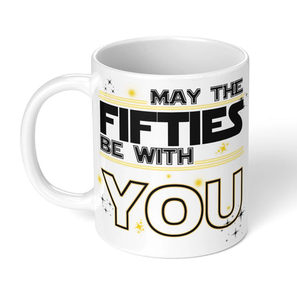 White ceramic mug with "MAY THE FIFTIES BE WITH YOU" in black and gold typography, decorated with stars - perfect 50th birthday gift
