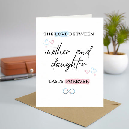 Mother and daughter love greeting card with hearts and infinity symbol on a desk