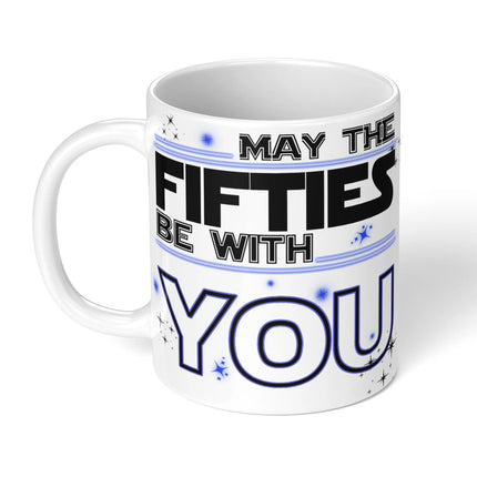 White ceramic mug with "MAY THE FIFTIES BE WITH YOU" in Star Wars-inspired black and gold typography, decorated with stars - perfect 50th birthday gift