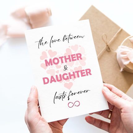 Woman holding the love between mother and daughter lasts forever card