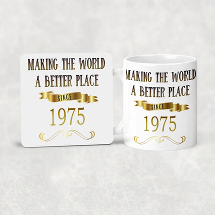 White mug and coaster set with gold text 'Making the world a better place since 1975' on a light gray background