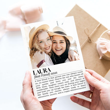 Person holding a card with two women's photo and the word 'Laura' printed on it.