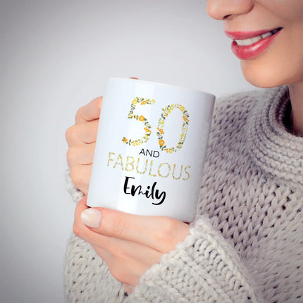 Person holding a mug with '50 and Fabulous Emily' text